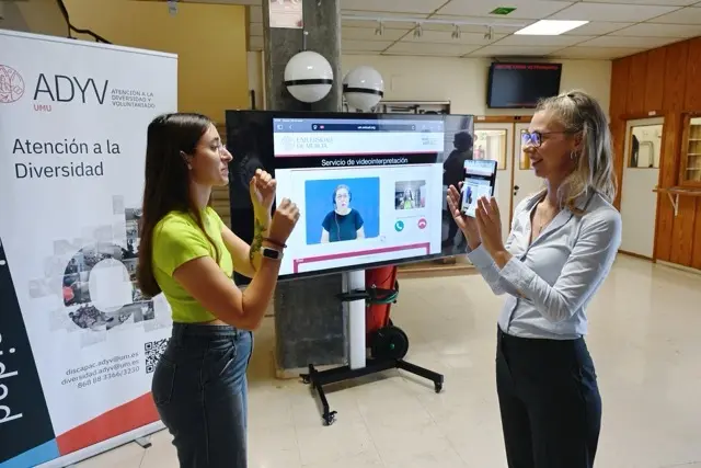 Una alumna y una técnica de la UMU se comunican en lengua de signos gracias a una intérprete por videoconferencia en tamaño mediano