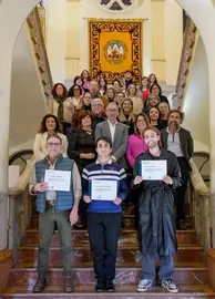 Fotografía de los premiados en el Curso de Fotografía contra la Violencia de Género junto a los asistentes al acto institucional