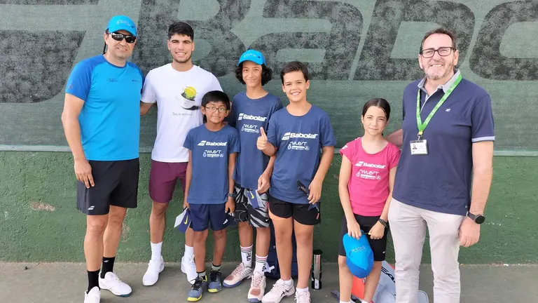Foto 1 Carlos Alcaraz, junto a Alfredo Sarriá (responsable de la escuela de tenis) y Jose Antonio García, Business Manager de ELIS Murcia, y niños participantes en el campus