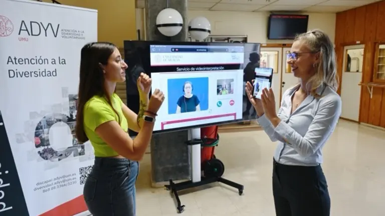 Una alumna y una técnica de la UMU se comunican en lengua de signos gracias a una intérprete por videoconferencia  en tamaño mediano